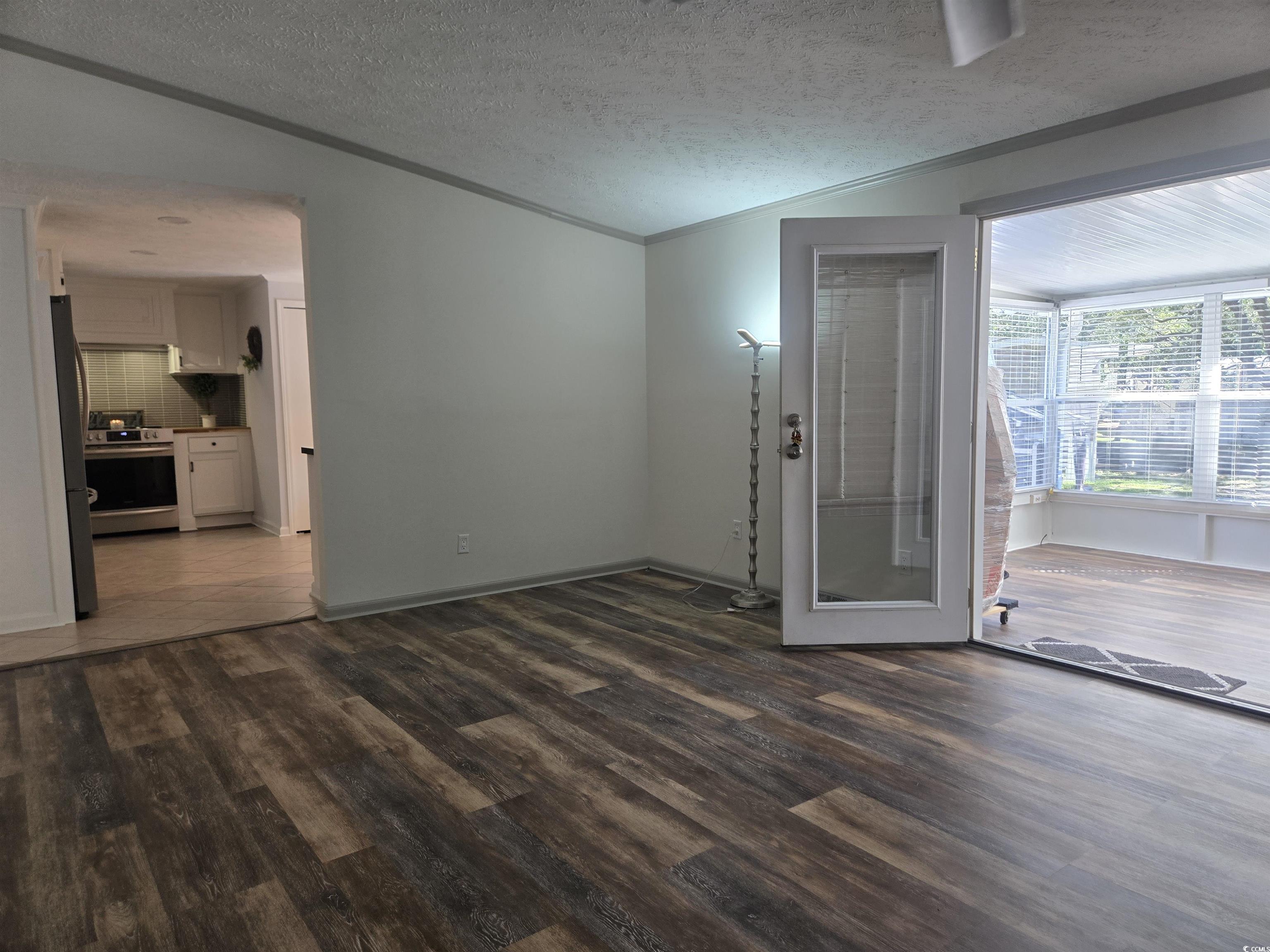359 Lagoon Circle Murrells Inlet, SC 29576 - Photo 18 of 39 Unfurnished room with dark wood-style flooring, crown molding, and a textured ceiling