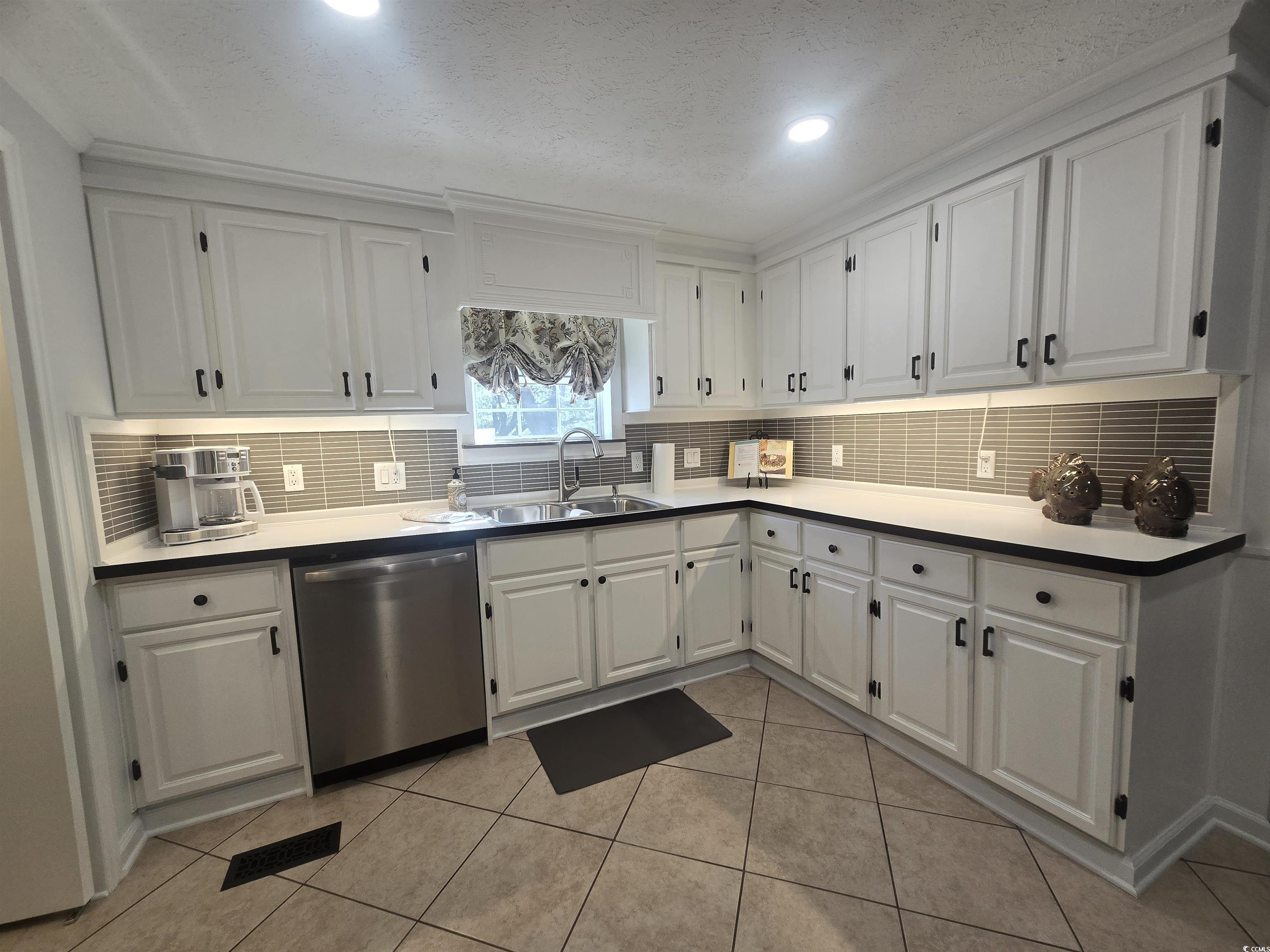 359 Lagoon Circle Murrells Inlet, SC 29576 - Photo 20 of 39 Kitchen featuring white cabinets, tasteful backsplash, stainless steel dishwasher, a textured ceiling, and light countertops