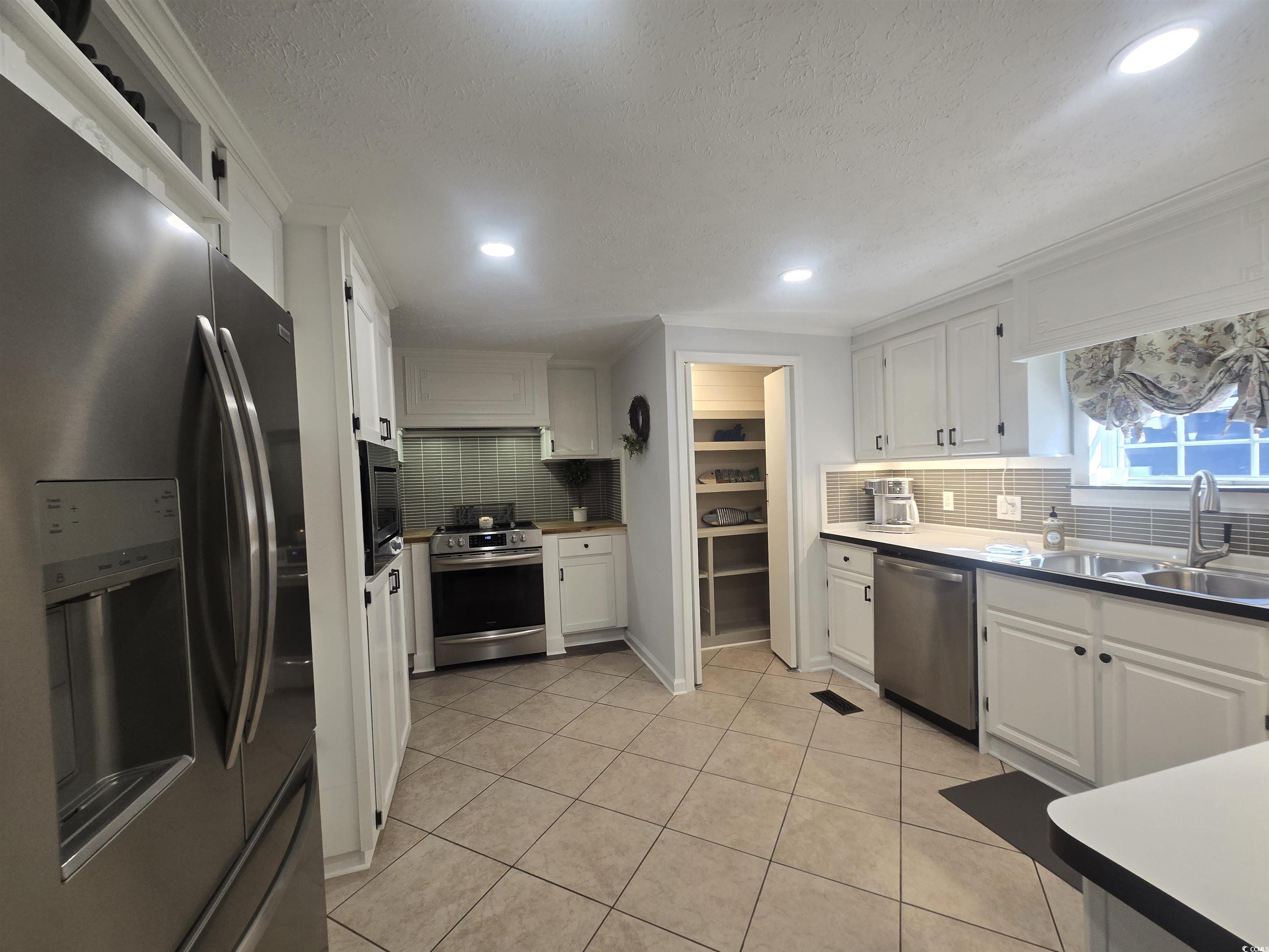 359 Lagoon Circle Murrells Inlet, SC 29576 - Photo 22 of 39 Kitchen with appliances with stainless steel finishes, white cabinets, light tile patterned flooring, a textured ceiling, and recessed lighting