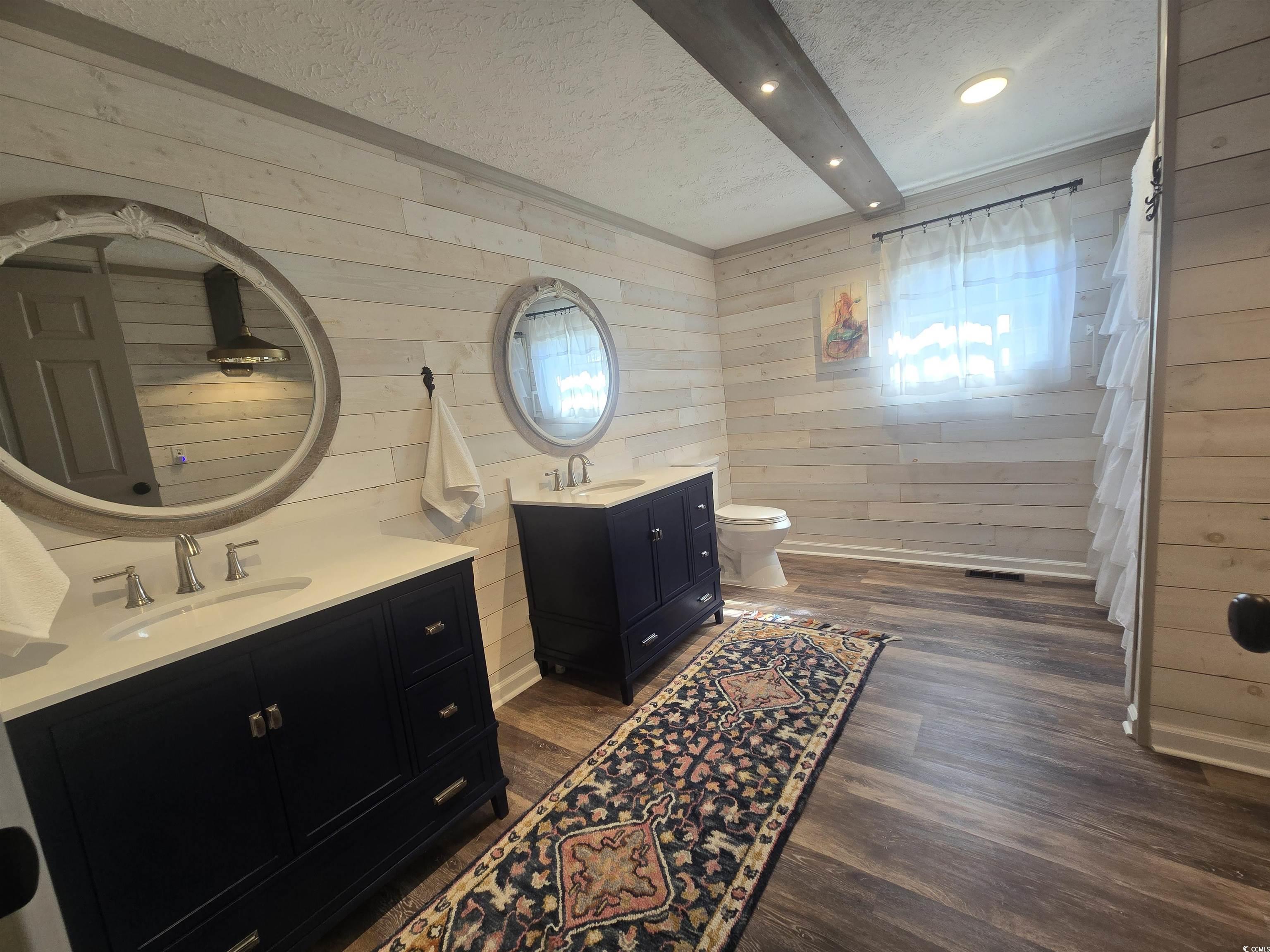 359 Lagoon Circle Murrells Inlet, SC 29576 - Photo 35 of 39 Bathroom featuring a textured ceiling, wood walls, two vanities, dark wood-type flooring, and recessed lighting