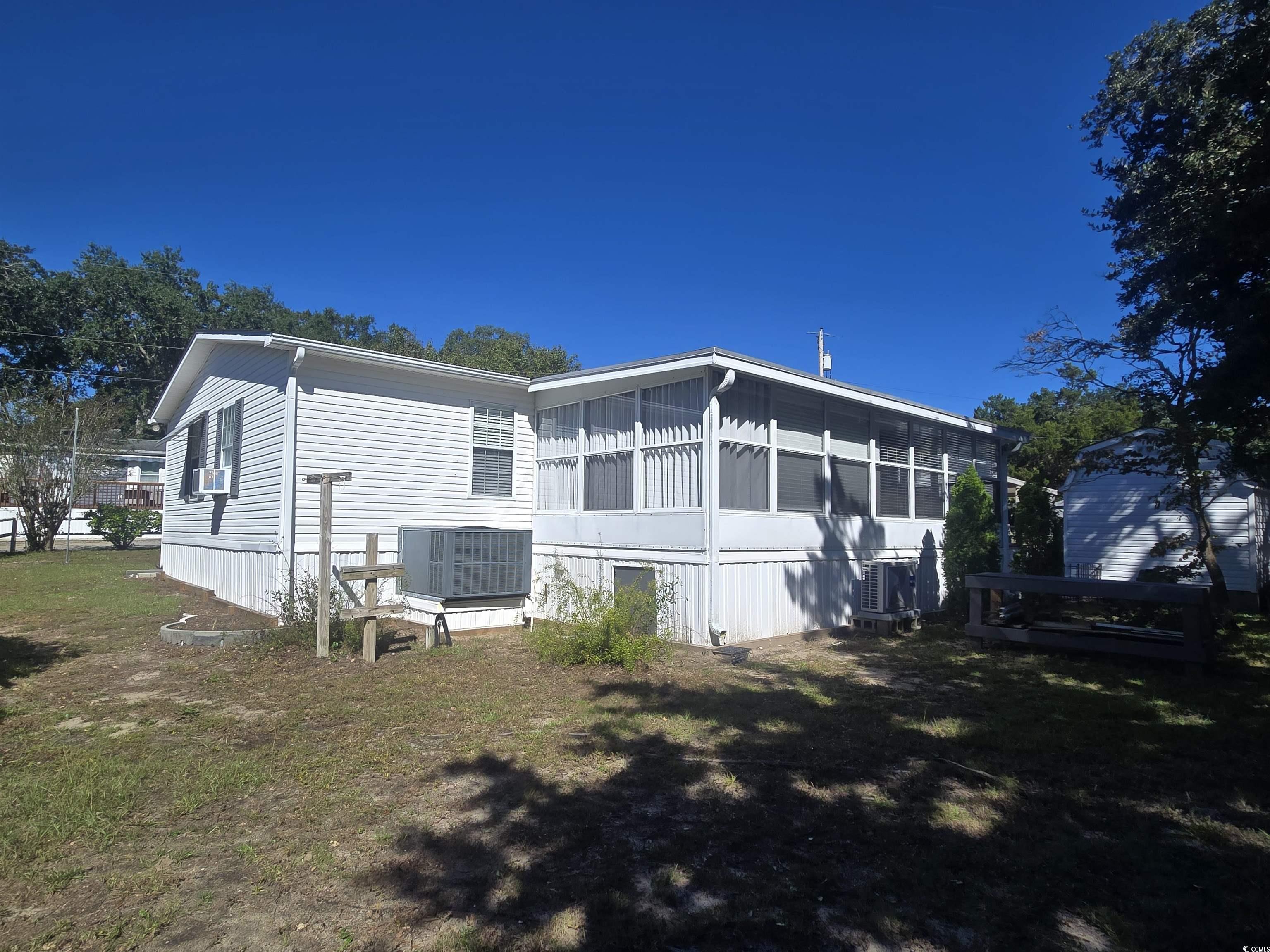 359 Lagoon Circle Murrells Inlet, SC 29576 - Photo 6 of 39 Back of property featuring a sunroom, a lawn, and a deck