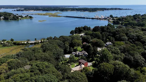 an aerial view of ocean with residential house with outdoor space and seating