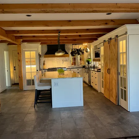 a large white kitchen with stainless steel appliances granite countertop a stove a sink and a microwave