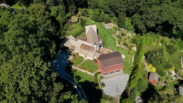 an aerial view of a house with a yard and trees