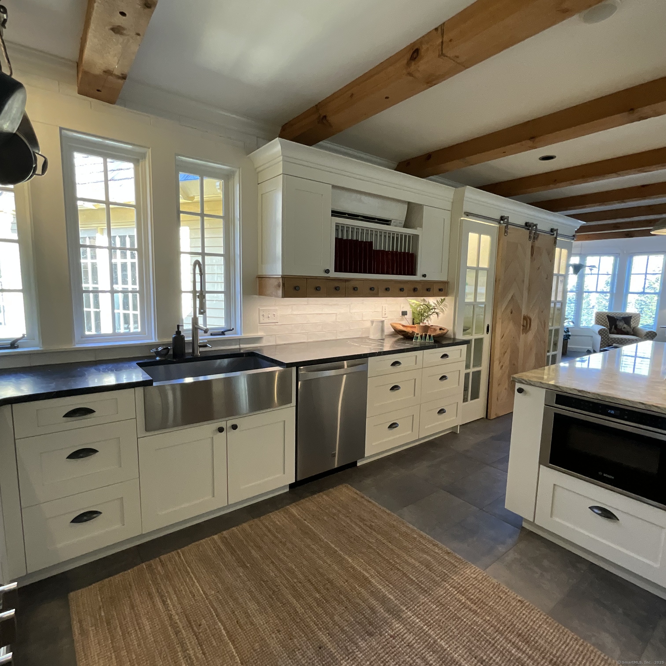 44 Brook Street Groton, CT 06340 - Photo 9 of 39 a large white kitchen with stainless steel appliances granite countertop a stove a sink and a microwave