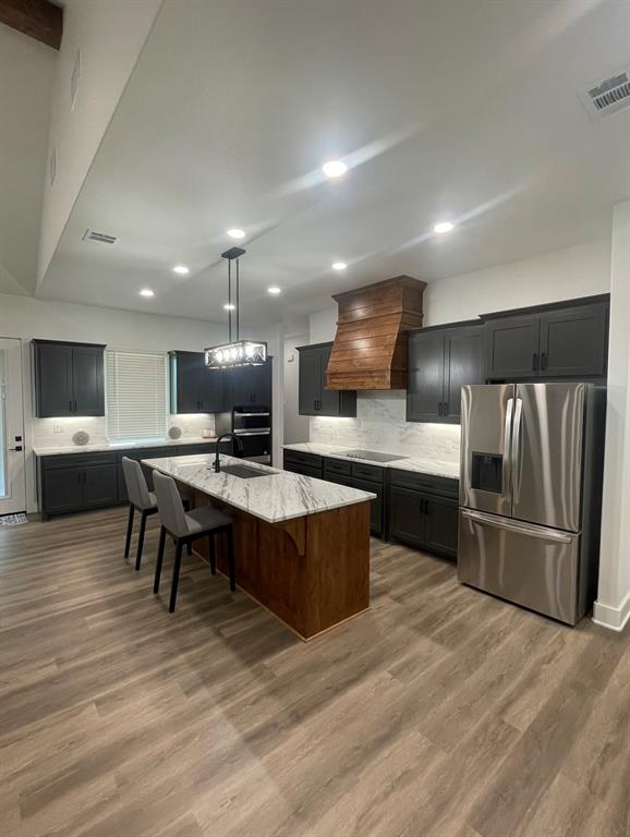 1484 Dixie Road Whitesboro, TX 76273 - Photo 4 of 18 a large kitchen with stainless steel appliances kitchen island granite countertop a table chairs and a refrigerator