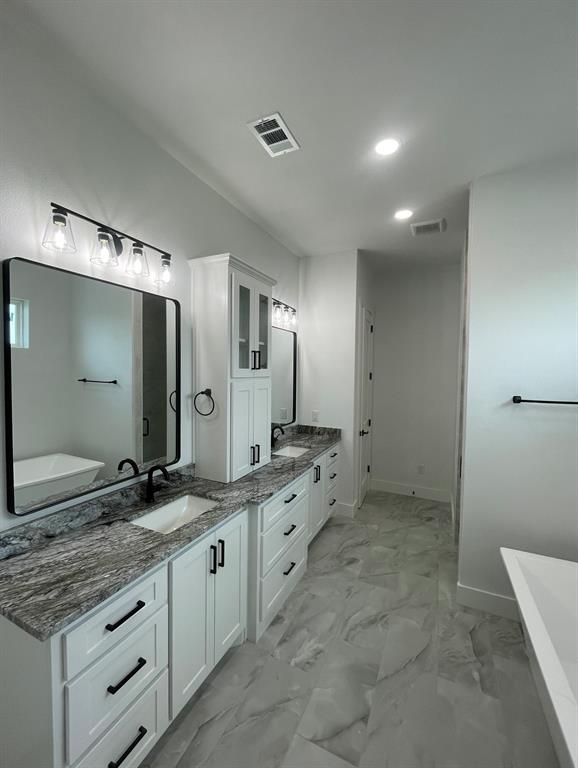 1484 Dixie Road Whitesboro, TX 76273 - Photo 7 of 18 a spacious bathroom with a granite countertop sink mirror and double
