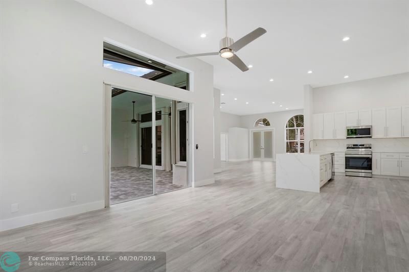 Cooper City Hollywood, FL 33024 - Photo 16 of 39 an empty room with wooden floor kitchen view and a window