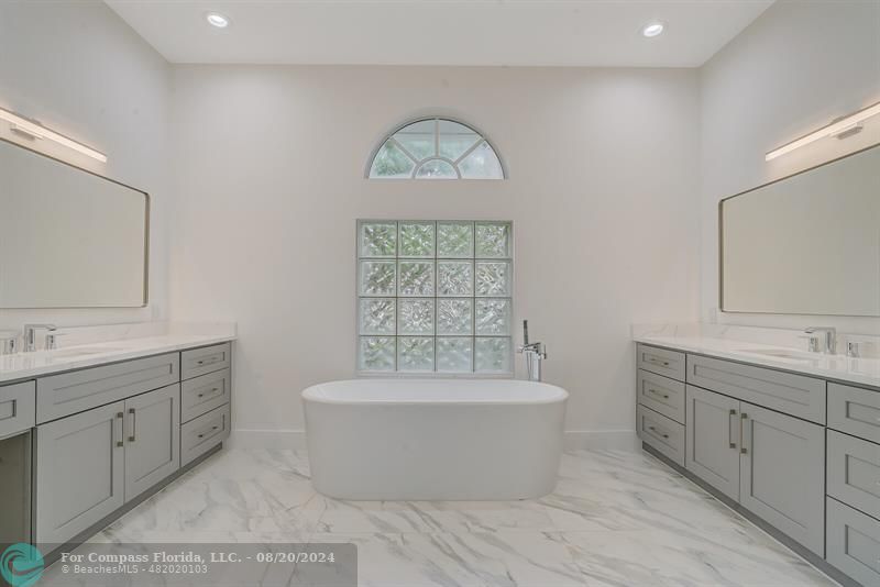 Cooper City Hollywood, FL 33024 - Photo 20 of 39 a spacious bathroom with a double vanity sink a mirror and a bathtub