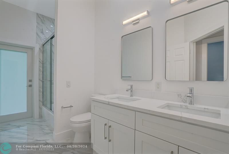 Cooper City Hollywood, FL 33024 - Photo 26 of 39 a bathroom with a toilet a sink a mirror and a shower