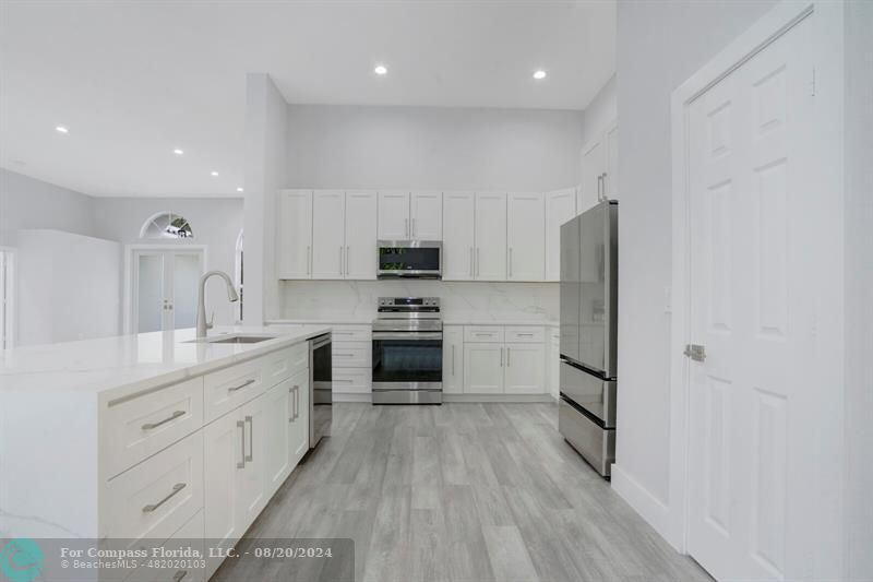Cooper City Hollywood, FL 33024 - Photo 6 of 39 a kitchen with white cabinets and stainless steel appliances