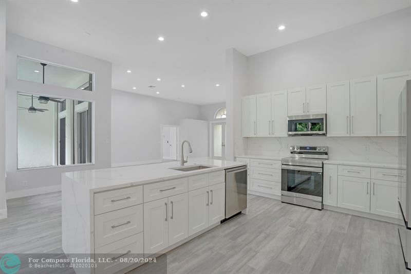 Cooper City Hollywood, FL 33024 - Photo 9 of 39 a kitchen with granite countertop white cabinets and stainless steel appliances