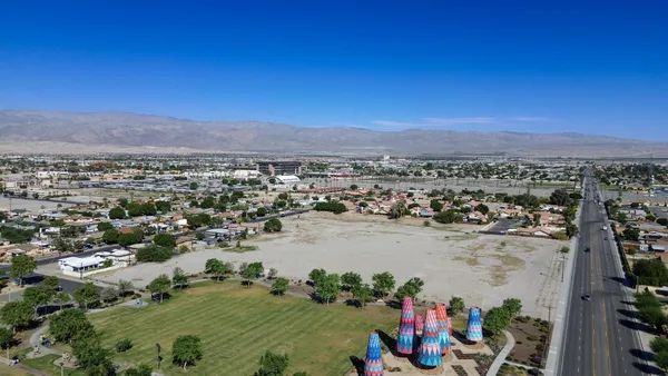an aerial view of a city with lots of residential buildings ocean and mountain view in back