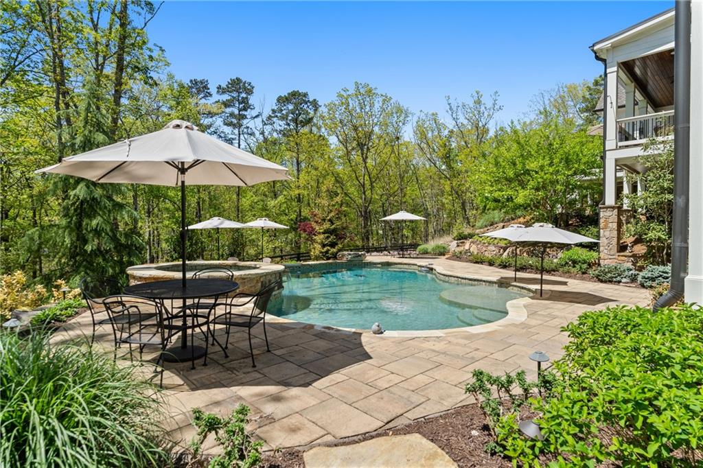 16200 Henderson Road Milton, GA 30004 - Photo 75 of 95 a view of a patio with chairs and a table and chairs under an umbrella