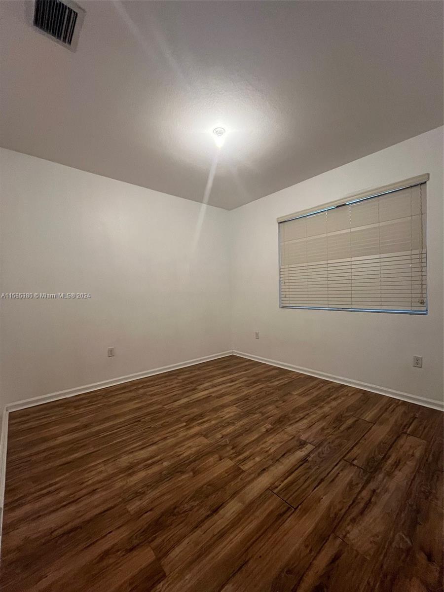 11879 Southwest 253rd Terrace Homestead, FL 33032 - Photo 12 of 26 a view of an empty room with wooden floor and a window