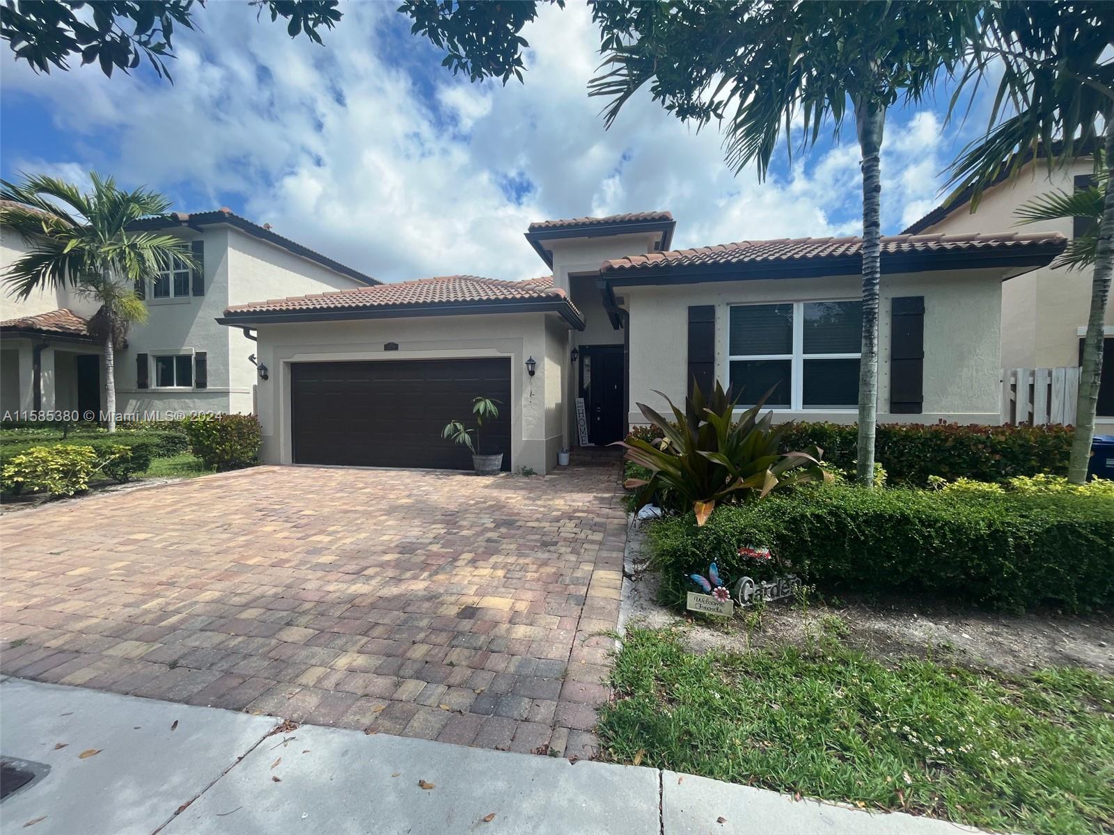11879 Southwest 253rd Terrace Homestead, FL 33032 - Photo 2 of 26 a front view of a house with a garden