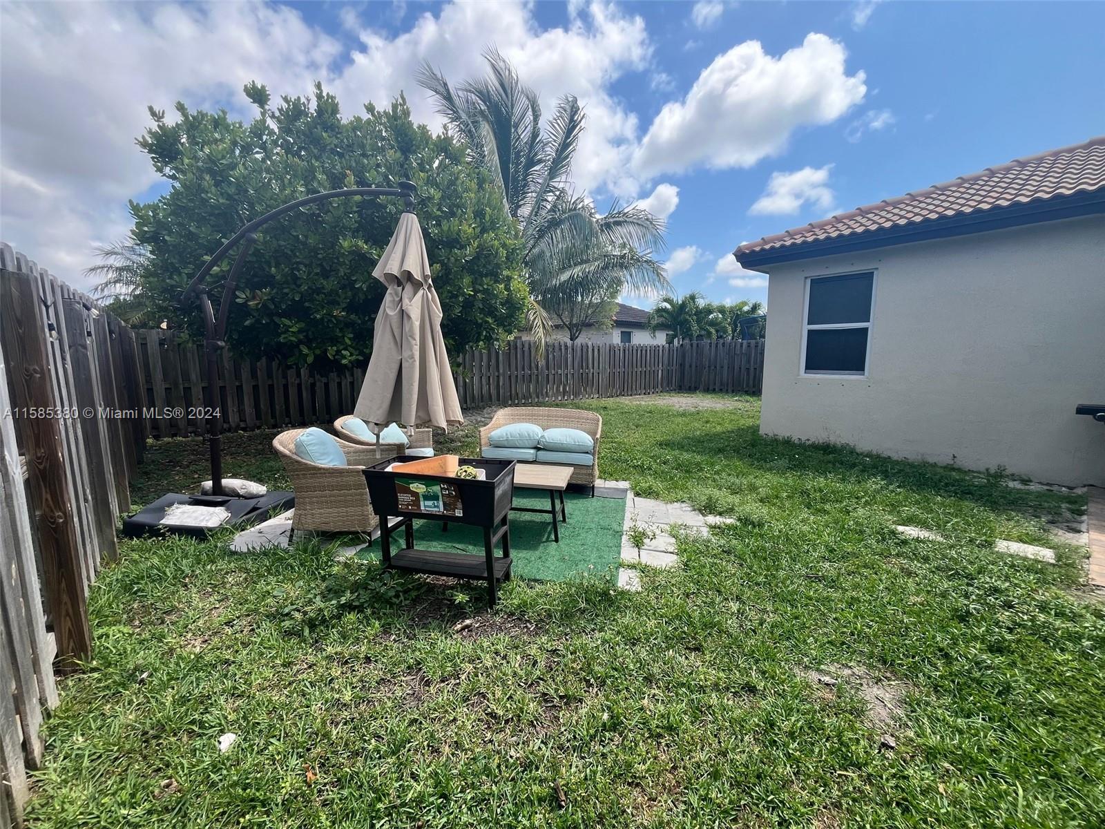 11879 Southwest 253rd Terrace Homestead, FL 33032 - Photo 22 of 26 a view of a backyard with table and chairs