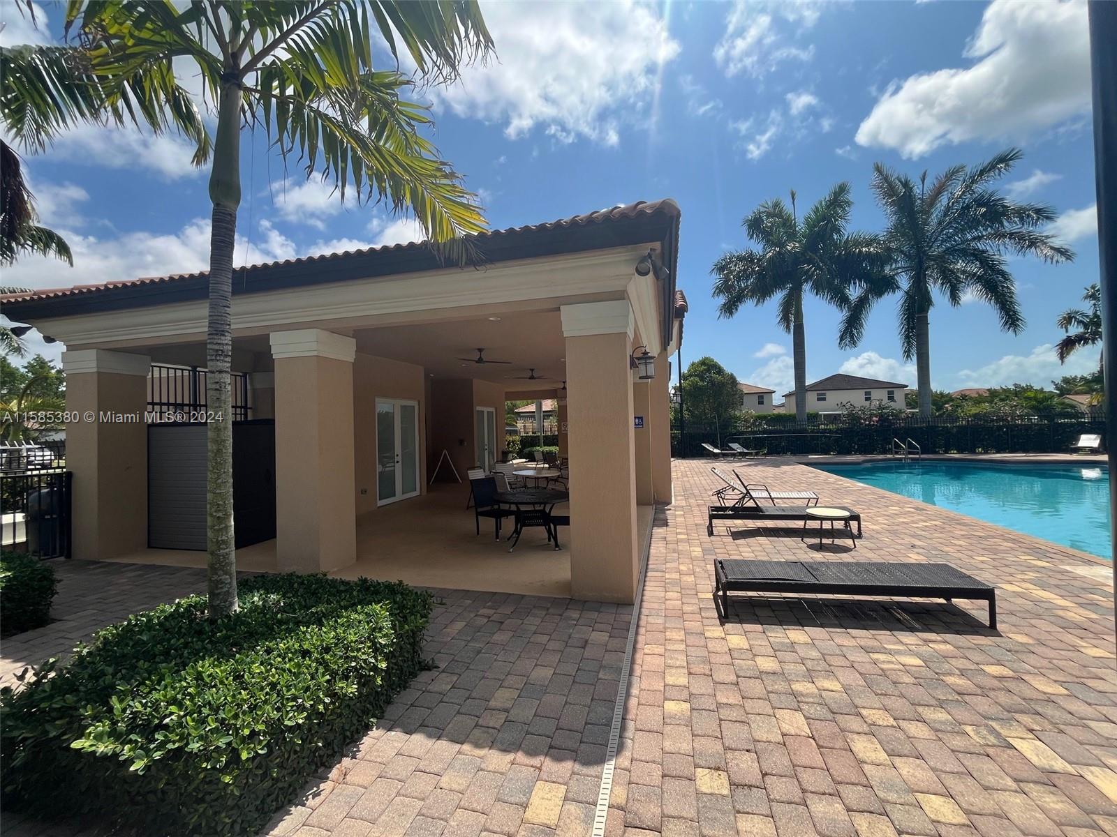 11879 Southwest 253rd Terrace Homestead, FL 33032 - Photo 25 of 26 a view of a patio with table and chairs potted plants and palm trees