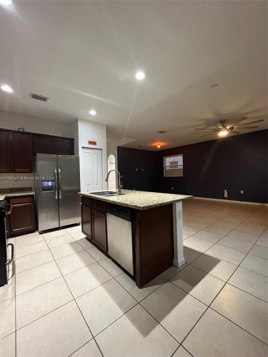 11879 Southwest 253rd Terrace Homestead, FL 33032 - Photo 6 of 26 a kitchen with stainless steel appliances kitchen island granite countertop a refrigerator and a stove