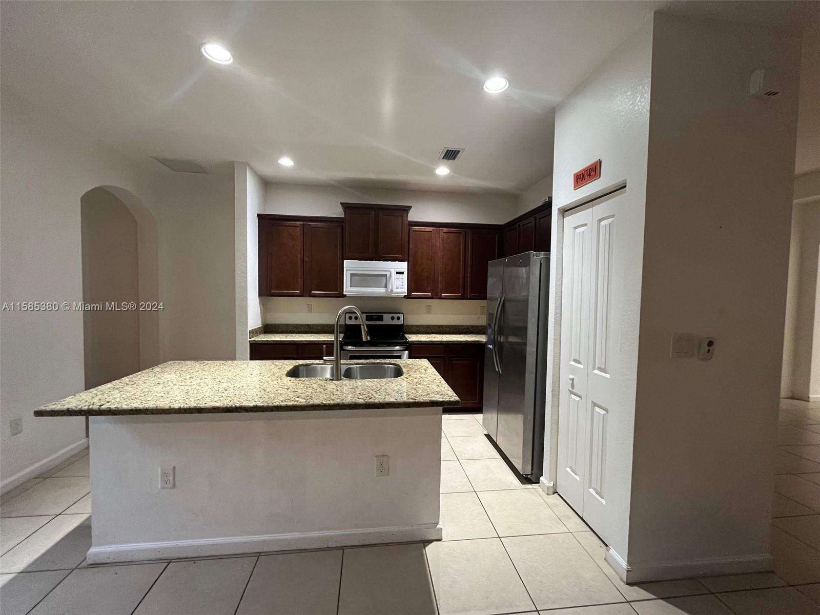 11879 Southwest 253rd Terrace Homestead, FL 33032 - Photo 7 of 26 a kitchen with stainless steel appliances granite countertop a refrigerator a sink and a stove