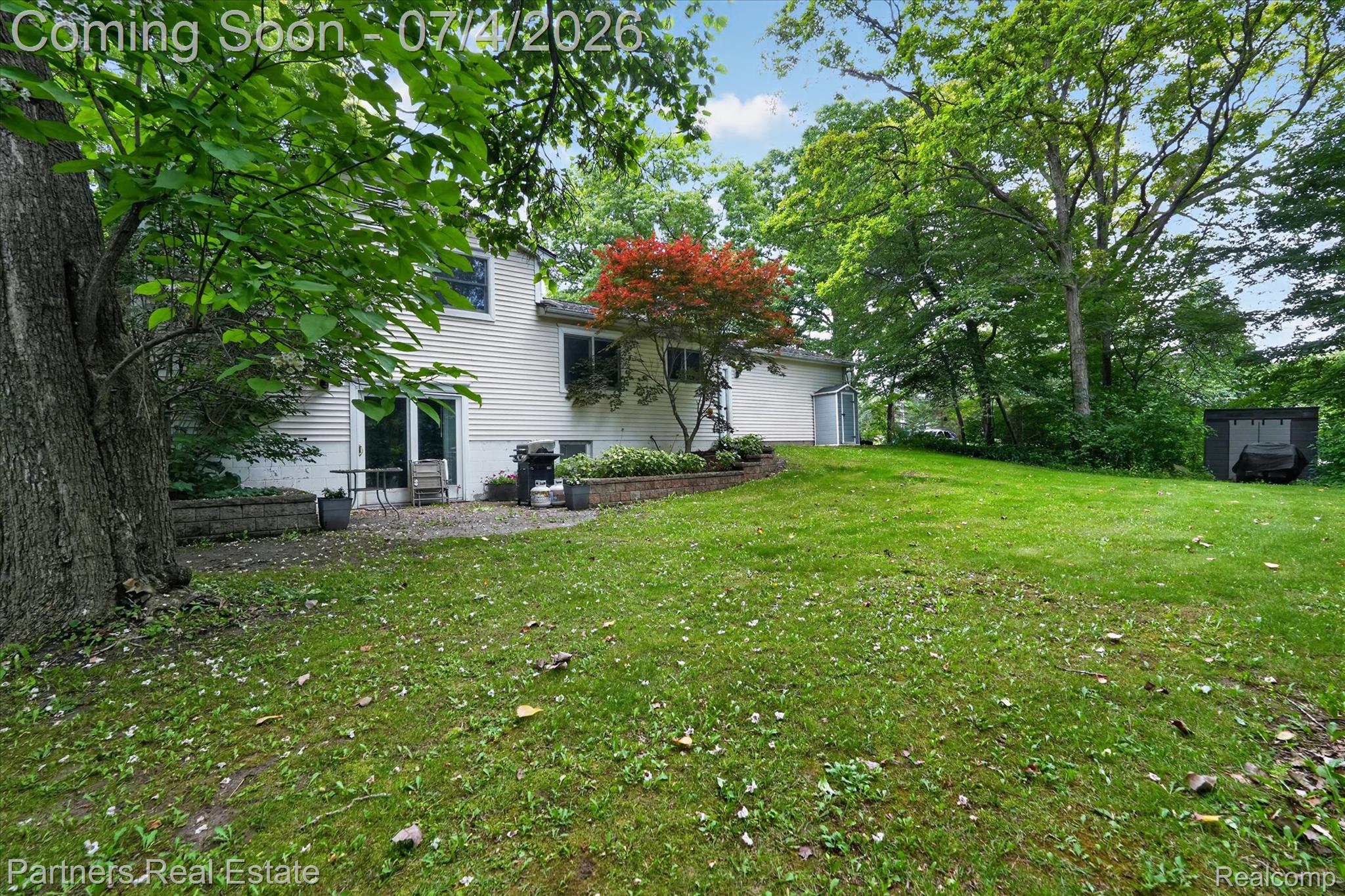 2500 Hubert Road Brighton, MI 48114 - Photo 37 of 53 Expansive backyard featuring a large green lawn, mature trees, and a concrete patio