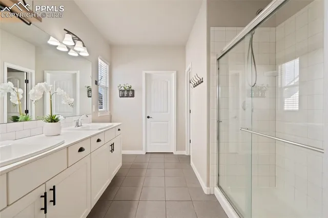 a bathroom with a double vanity sink and mirror with shower
