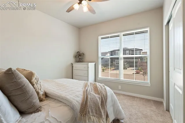 a bed sitting in a bedroom next to a window and a chandelier