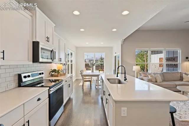 a kitchen with stainless steel appliances a stove sink microwave and cabinets