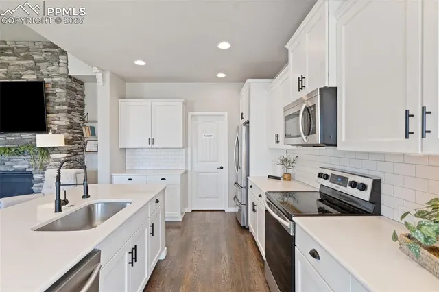 a kitchen with a sink stove top oven and refrigerator