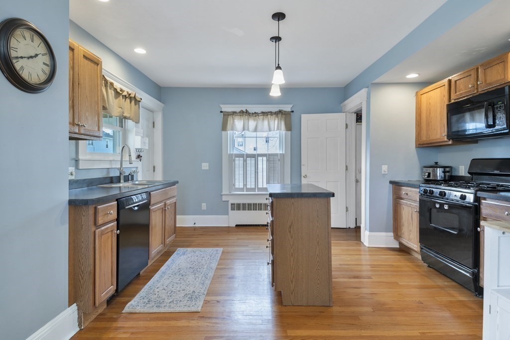 128 Shawmut Street Springfield, MA 01108 - Photo 14 of 39 a large kitchen with stainless steel appliances granite countertop a stove a sink dishwasher and a refrigerator with wooden floor