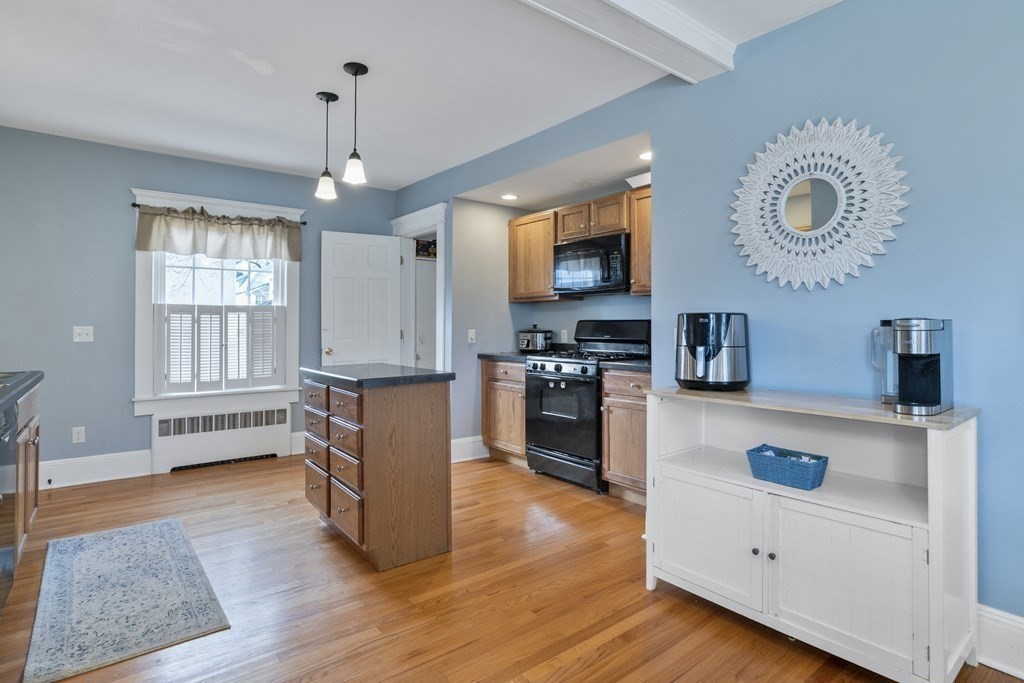 128 Shawmut Street Springfield, MA 01108 - Photo 15 of 39 a kitchen with kitchen island white cabinets and stainless steel appliances