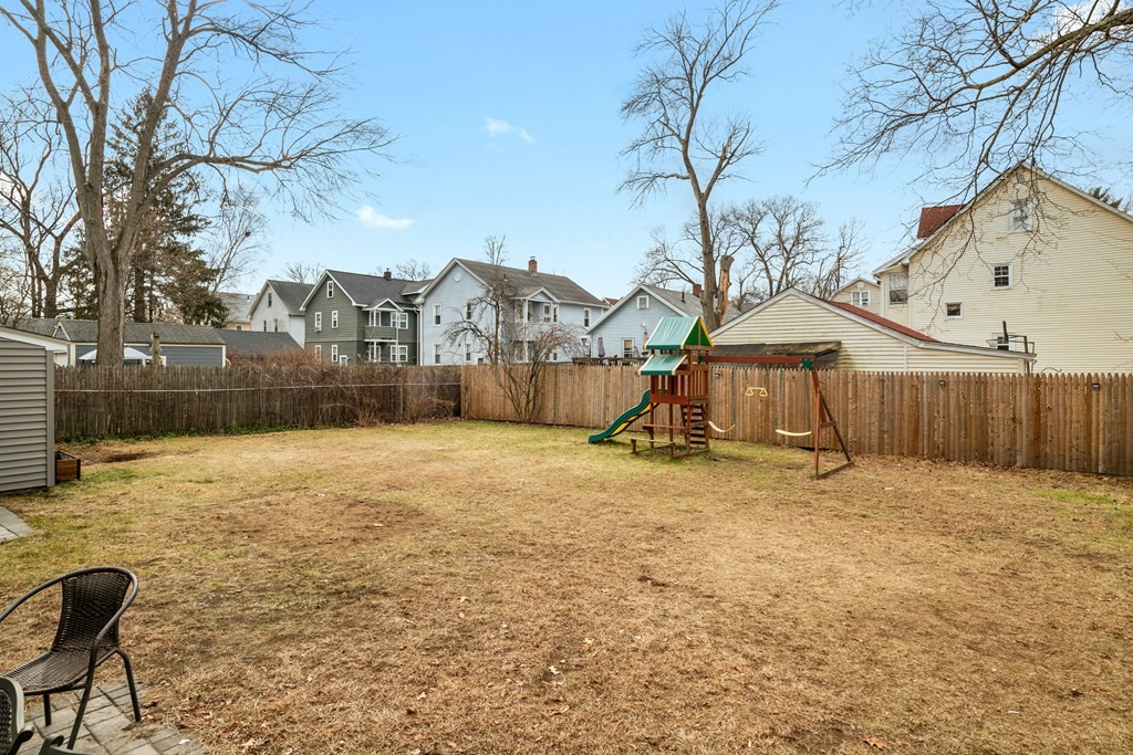 128 Shawmut Street Springfield, MA 01108 - Photo 39 of 39 a backyard of a house with large trees and outdoor seating