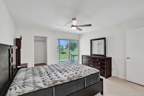 a bedroom with a bed and a flat tv screen on the dresser