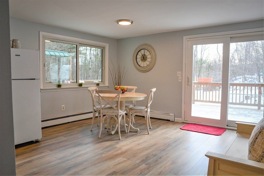 144 Partridgeville Road Templeton, MA 01468 - Photo 3 of 33 a dining room with wooden floor a glass table and chairs