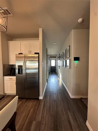 a kitchen with stainless steel appliances a refrigerator and wooden floor