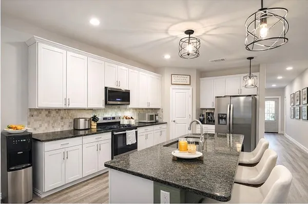 a kitchen with stainless steel appliances granite countertop a sink refrigerator and cabinets