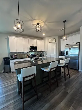 a view of kitchen with sink microwave and dining table