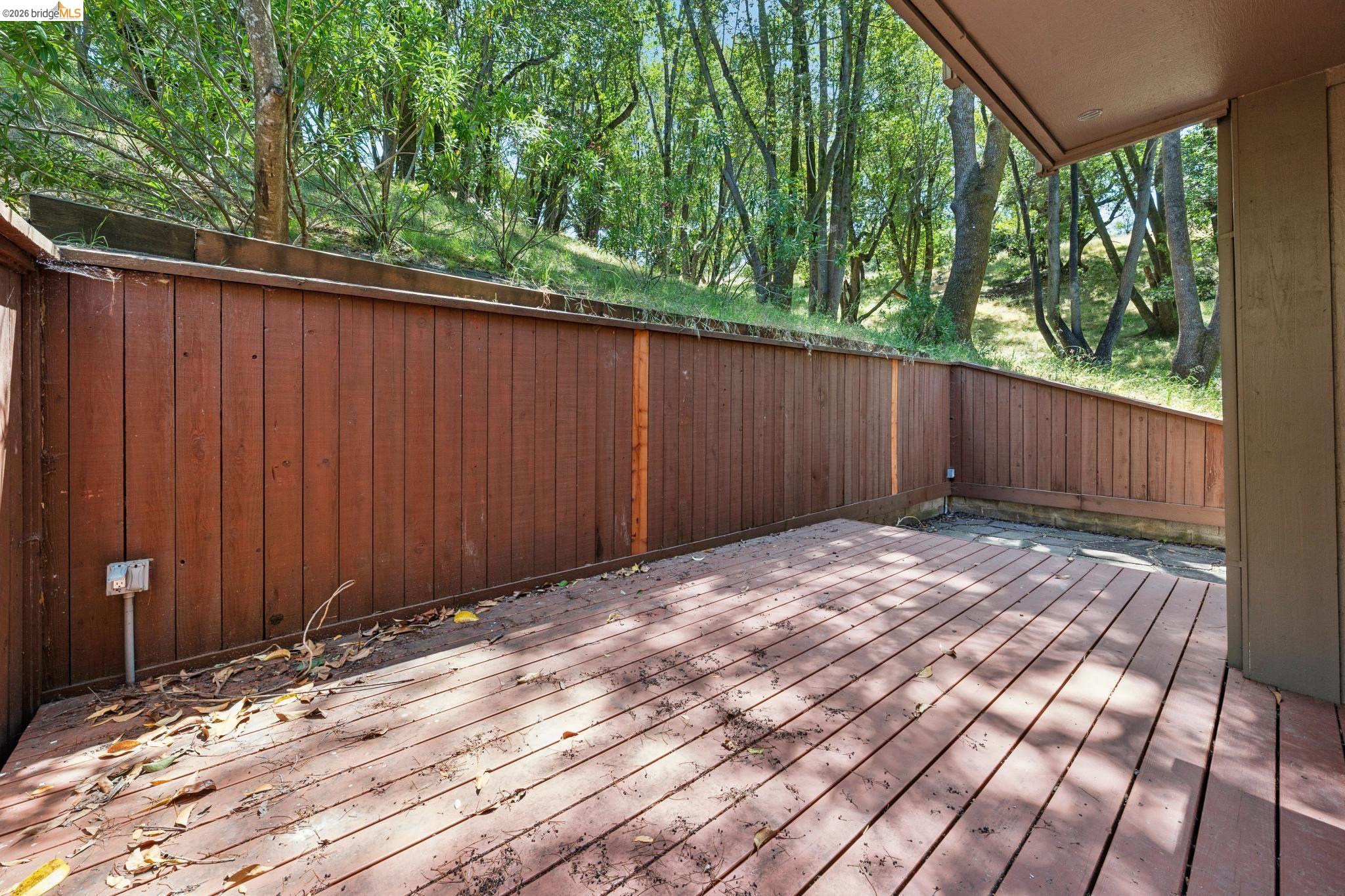 261 Redhawk Road Novato, CA 94949 - Photo 42 of 44 Spacious outdoor deck featuring natural wood decking, a solid wood privacy fence, and a wooded hillside backdrop