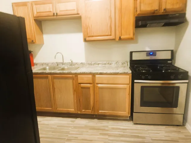 a kitchen with stainless steel appliances granite countertop a stove a microwave and a refrigerator