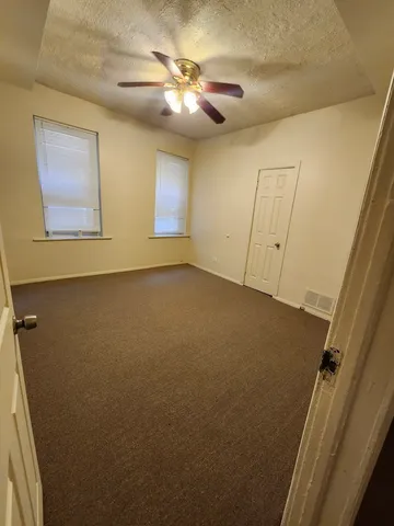 en empty room with windows and fan