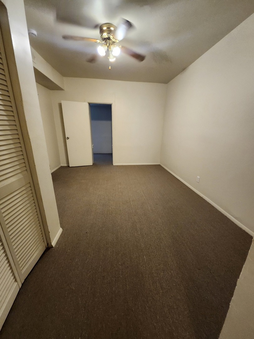 6730 South Clyde Avenue, Unit 1 Chicago, IL 60649 - Photo 7 of 8 wooden floor in an empty room with a window