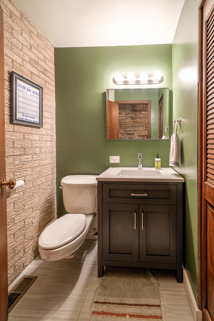 916 Forest Drive Elgin, IL 60123 - Photo 17 of 26 a bathroom with a sink toilet and mirror