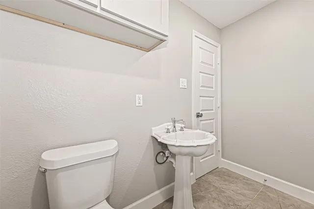 a bathroom with a granite countertop sink a toilet and a mirror