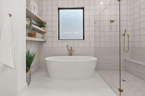 a white bath tub sitting in a bathroom next to a shower