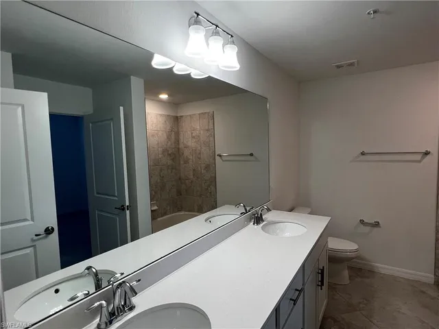 a bathroom with a sink a light fixture and a toilet