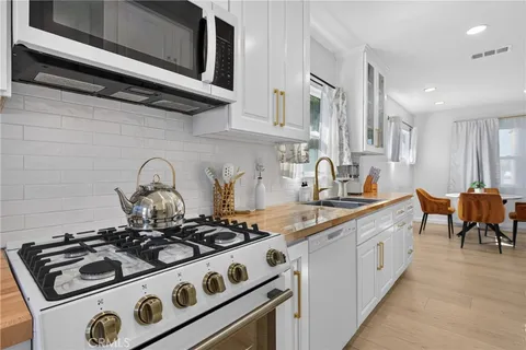 a kitchen with stainless steel appliances a sink a stove and cabinets