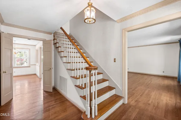 an empty room with wooden floor and windows with curtains view