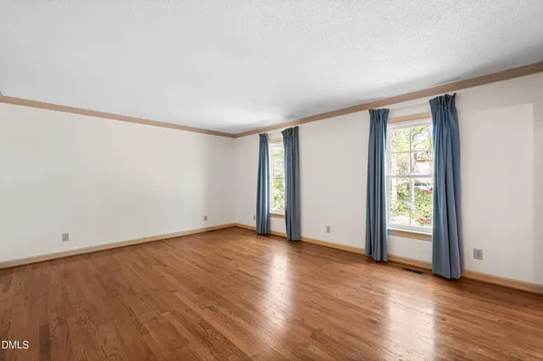 a view of an empty room with wooden floor
