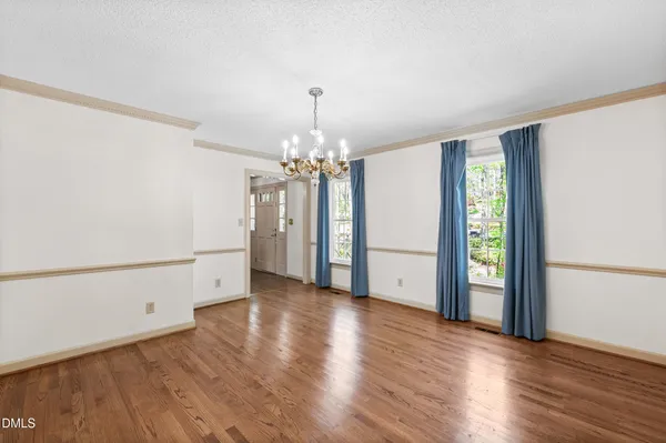 a view of a room with wooden floor and chandelier