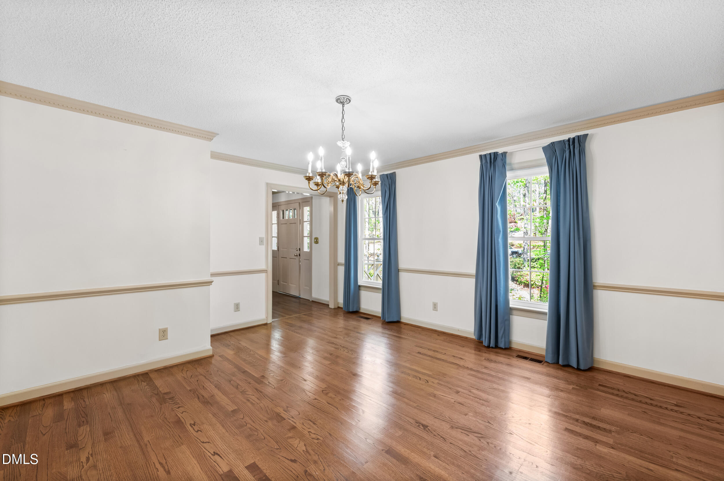 109 Queensferry Road Cary, NC 27511 - Photo 18 of 48 an empty room with wooden floor chandelier and windows